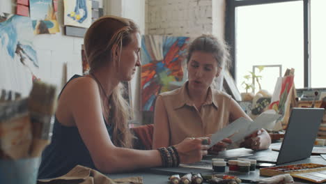 two artists discussing artwork in a studio