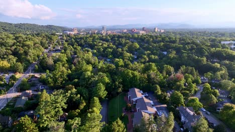 aerial push in to asheville nc, north carolina in the distance through homes and neighborhoods