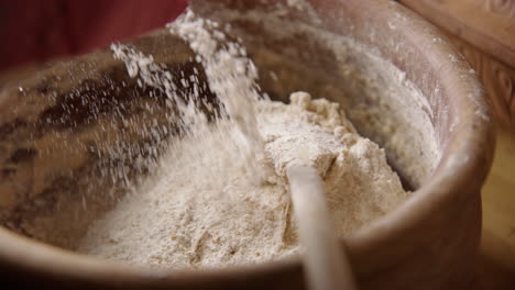 baking - hand sprinkling flour on batter, sourdough bread baking, slow motion