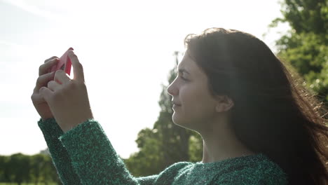 pretty italian woman tourist taking photograph of a park in wimbledon london