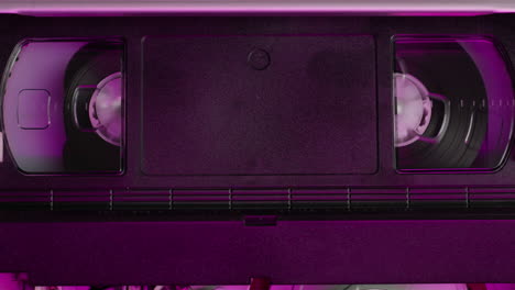 vhs-player, alter videorekorder im inneren in neonrosa licht nahaufnahme, vhs. retro-player in neonblauem licht, vintage-videokassetten-sendung, audioband.