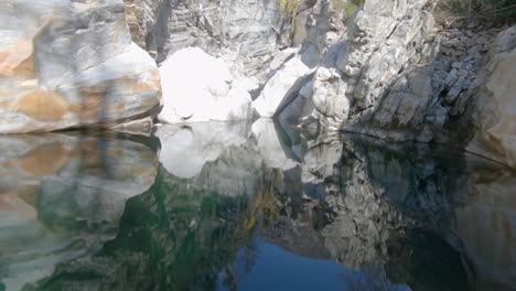 Epischer-Fpv-drohnenfilmflug-In-Einer-Winzigen-Klippe-Mit-Einem-Fluss-In-Der-Schweizer-Wildnis