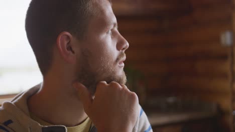 Caucasian-man-spending-time-at-home-looking-at-the-window