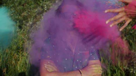 slow motion portrait of smiling arab man enjoying holi festival while people throwing paint powder at him