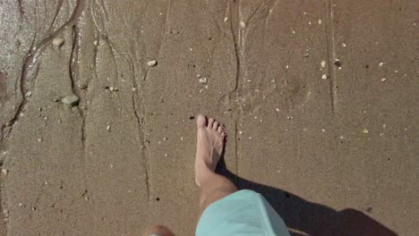 Closeup-of-feet-while-walking-on-sand-of-norther-sea-shoreline-in-Zeeland,-Netherlands---4k60