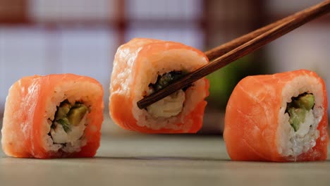 salmon sushi rolls with chopsticks