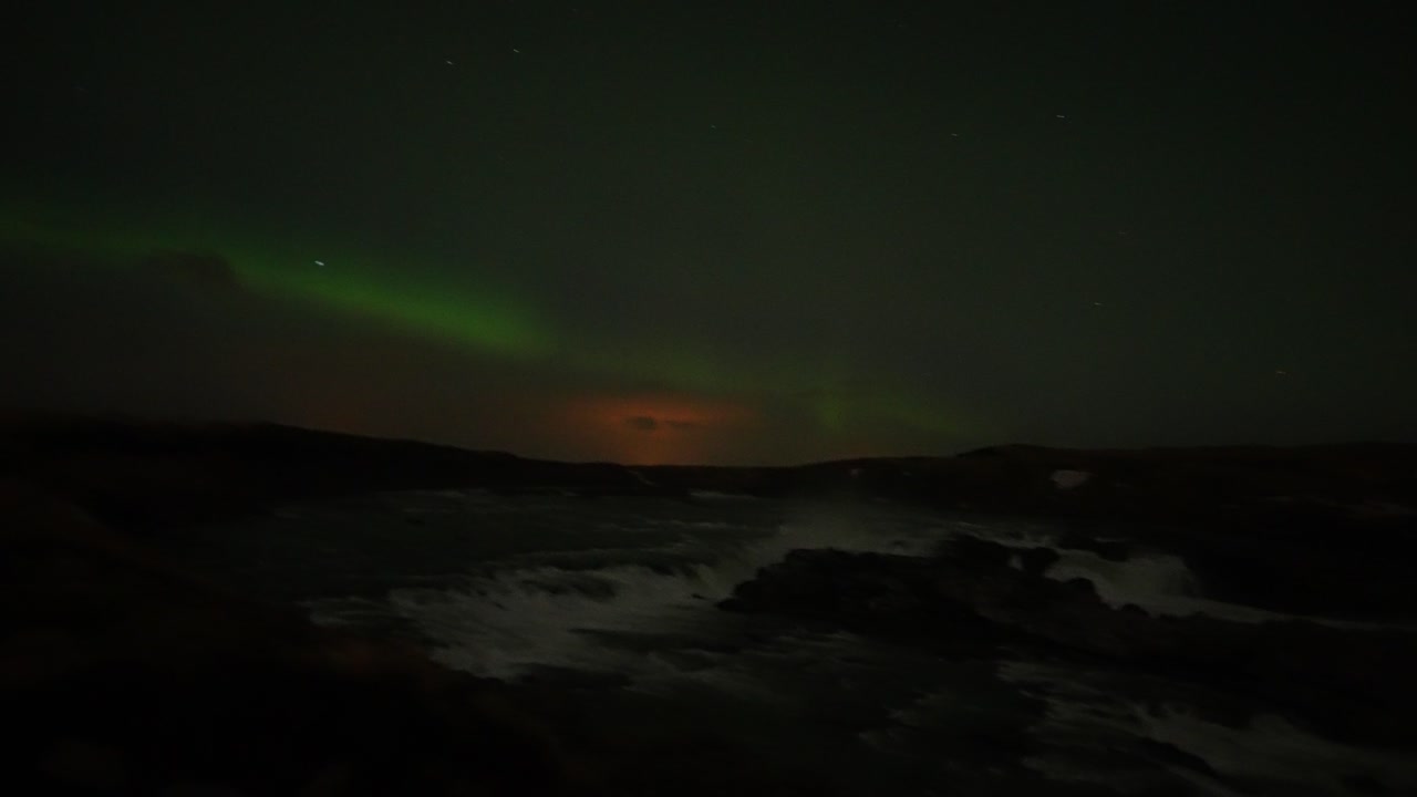 vista nocturna panorámica de la aurora boreal iluminando el cielo sobre la cascada urridafoss en el suroeste de islandia