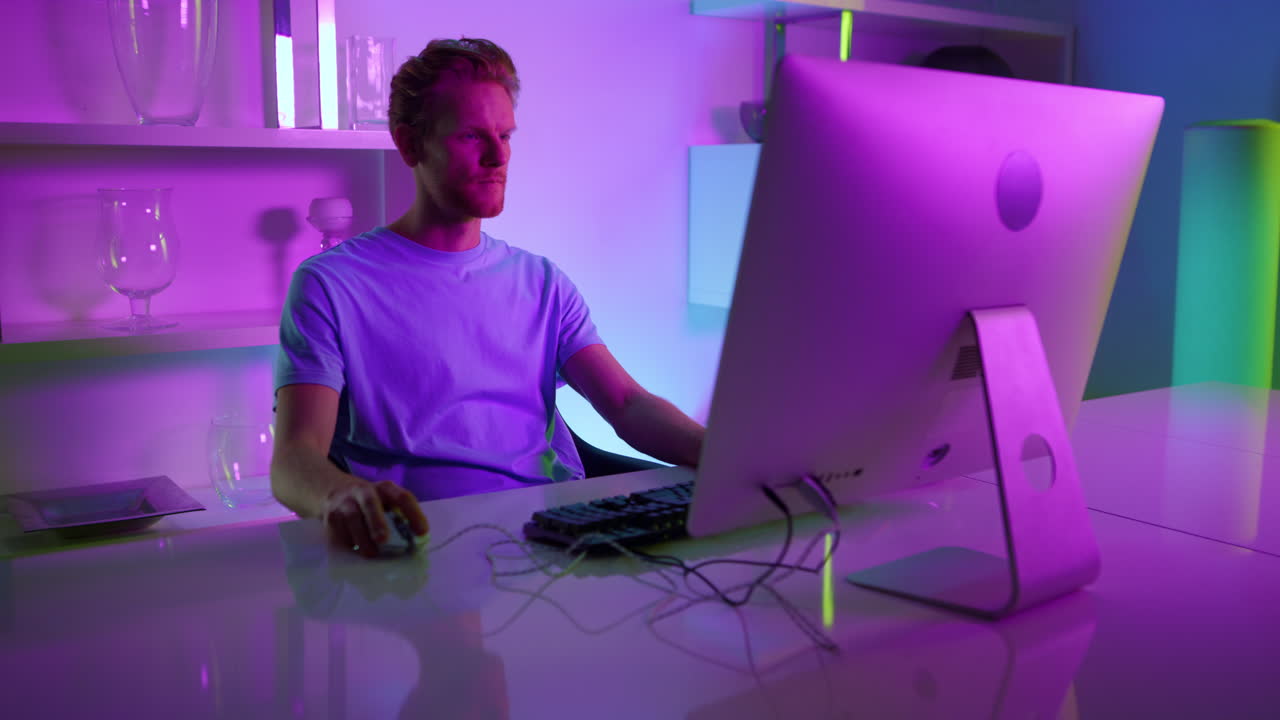 Focused gamer playing video game. Creative architect make project in neon lights