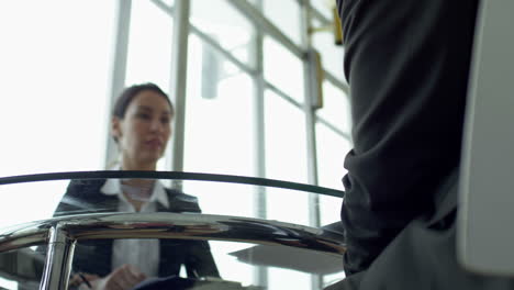 vista inferior de la mujer de negocios en una reunión con compañeros de trabajo sentados en una mesa