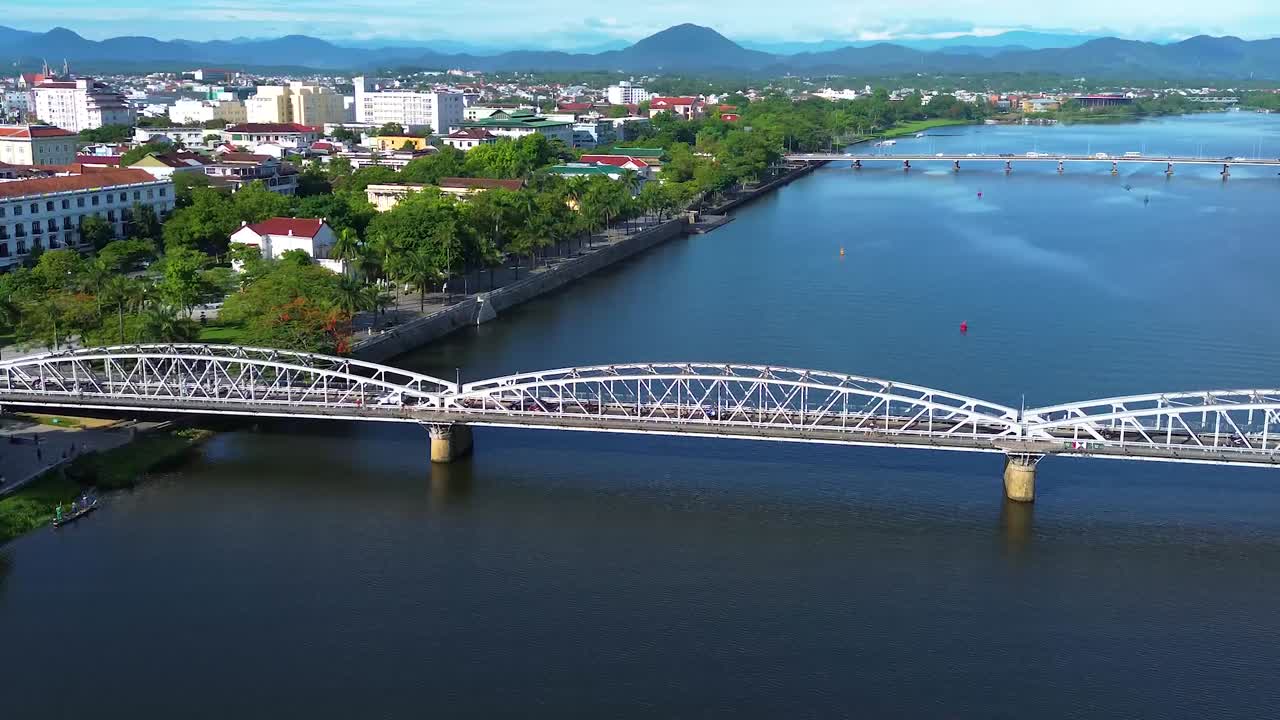 Aerial panning shot of cars crossing the Truong Tien Bridge with the Perfume River below in Hue