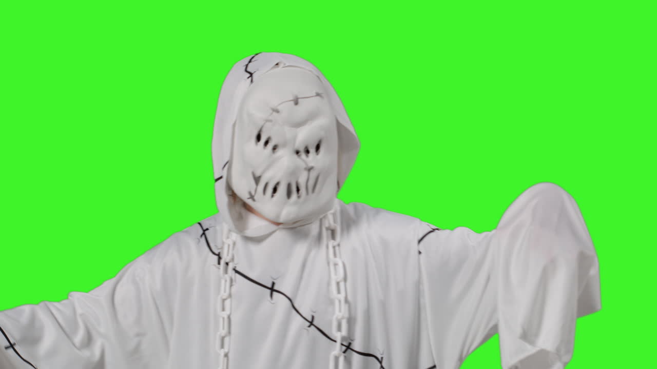 유령, 좀비, 괴물 의상을 입은 아이가 할로윈에 사람들을 겁내며 스튜디오 녹색 스크린을 배경으로합니다.