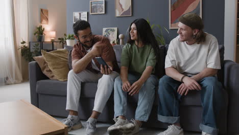three friends talking on a couch in a living room