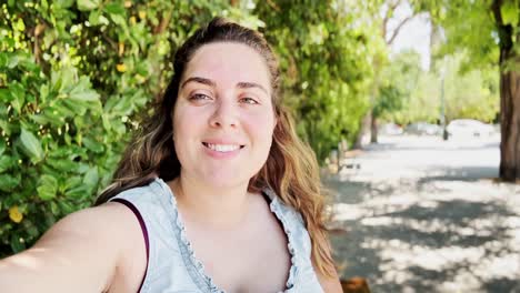 friendly young woman vlogging her sunny day in athens garden