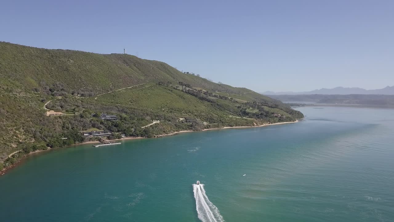 Ripresa aerea dall'alto di un motoscafo che solleva una scia bianca nel canale della laguna.