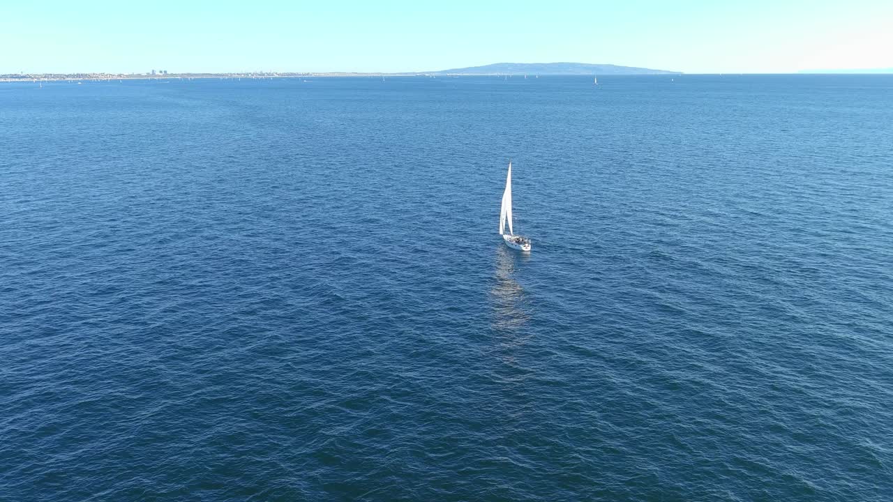 volando sobre un velero en el océano pacífico frente a la costa de pacific palisades california | toma aérea de sobrevuelo | tarde soleada