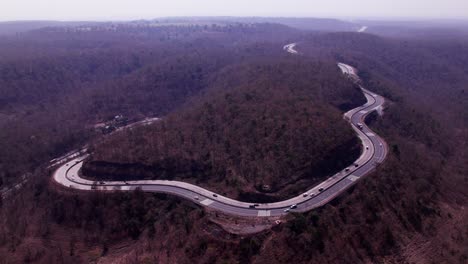ghat road in madhya pradesh with trees and moving vehicles at day time, moving up, drone shot, 4k.