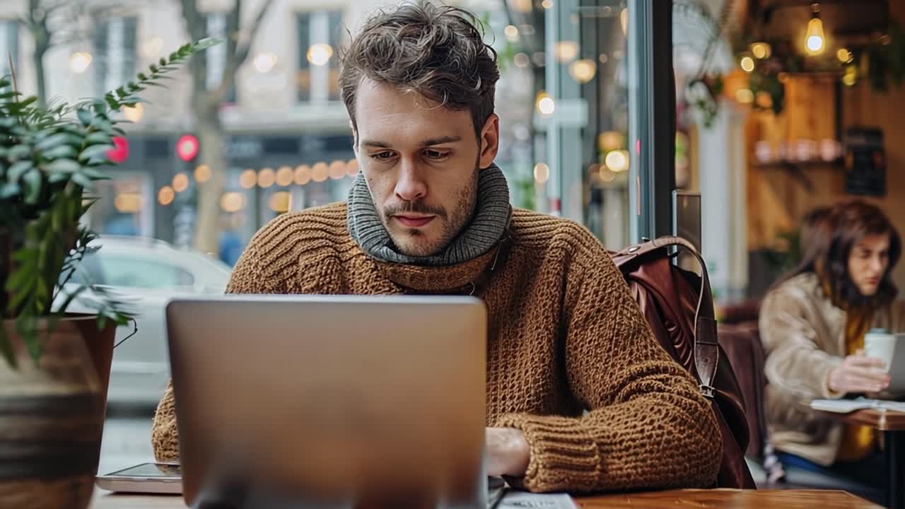 Man Working on Laptop in a Cafe