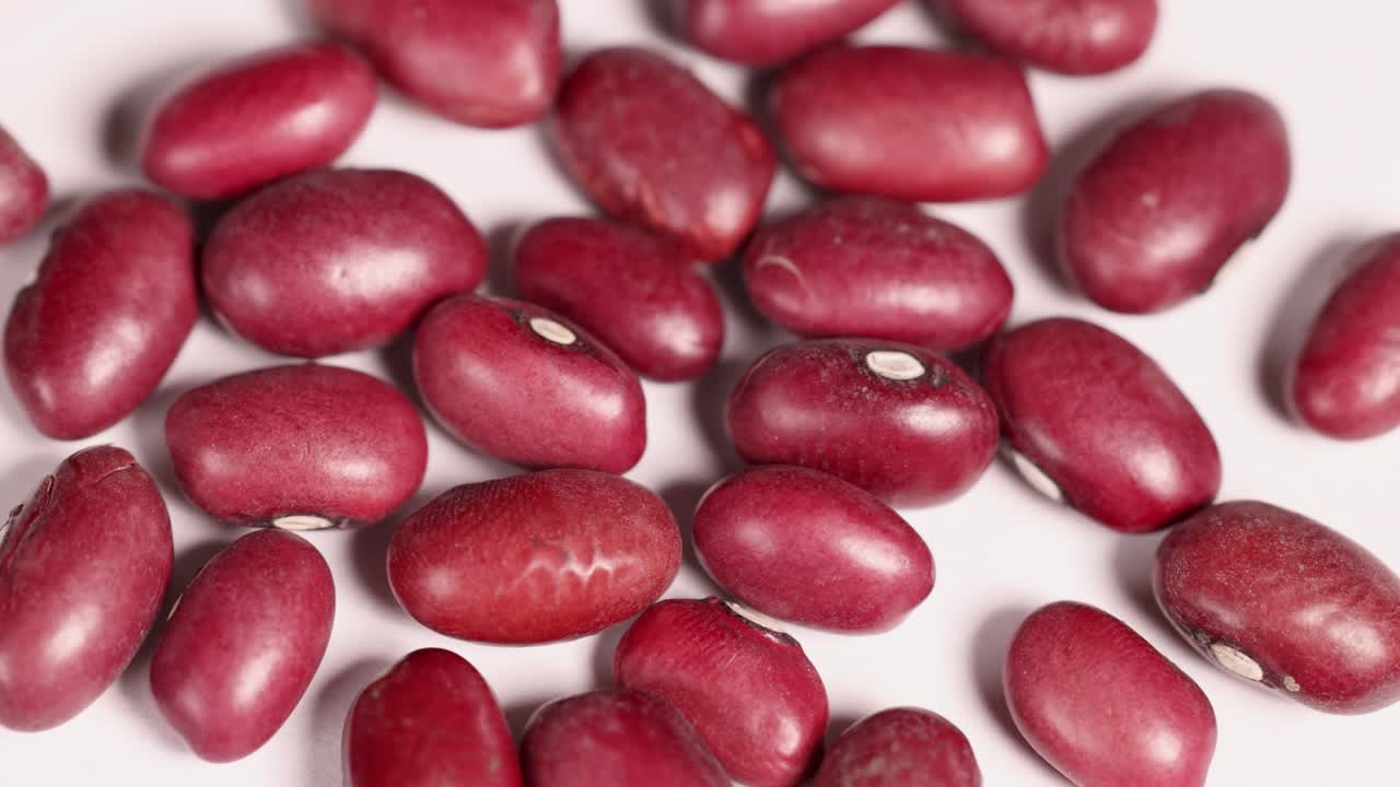 Close-up video of red bean seeds shifting slightly, highlighting texture and color under bright lighting