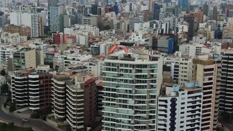 the costa verde-malecon in miraflores, lima, with a paraglider in the city skyline, aerial view