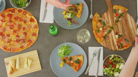 vista aérea de amigos comiendo pizza en un restaurante juntos