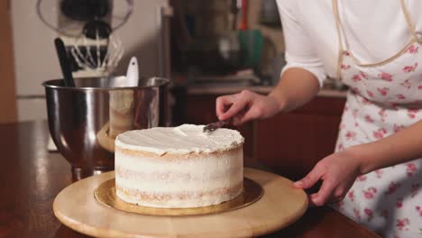 woman decorating a layered cake