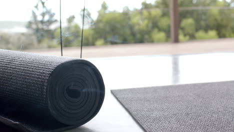 yoga mat rolled up on floor, ready for home workout or meditation session