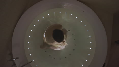 둥근 스파 욕조에서 휴식을 취하는 여자