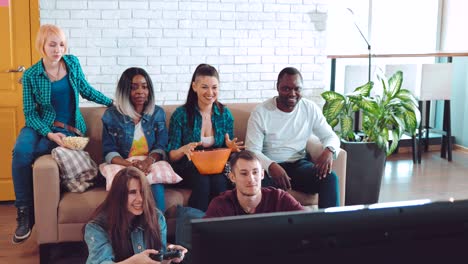 company of different nationalities friends play fun games on the console. friendly party