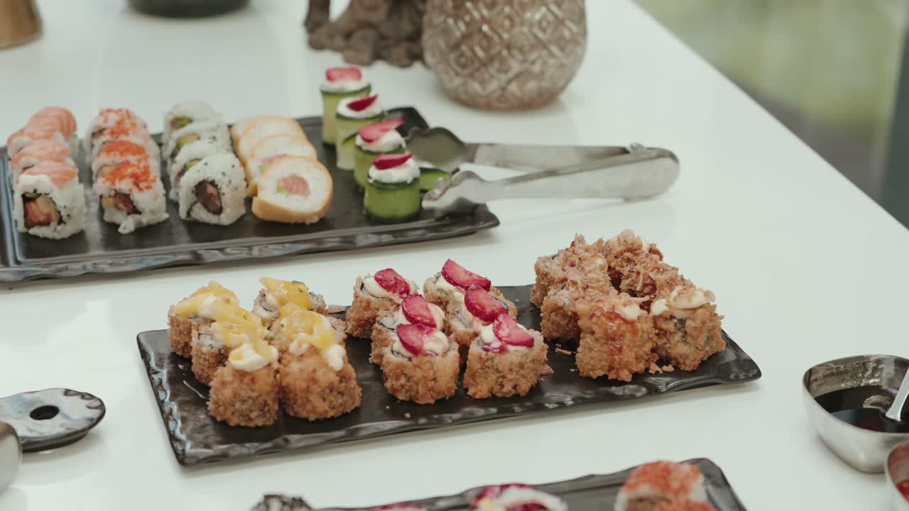 colorful sushi selection with fruit and sauce toppings arranged on black plates
