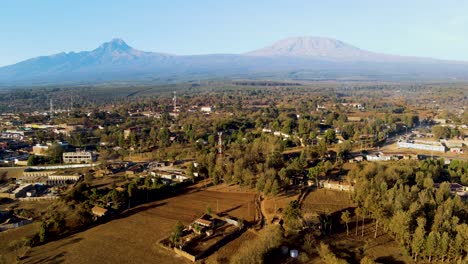 Sonnenaufgang-–-Kenia-Landschaft-Mit-Einem-Dorf,-Kilimandscharo-Und-Amboseli-Nationalpark-–-Verfolgung,-Drohnen-Luftaufnahme