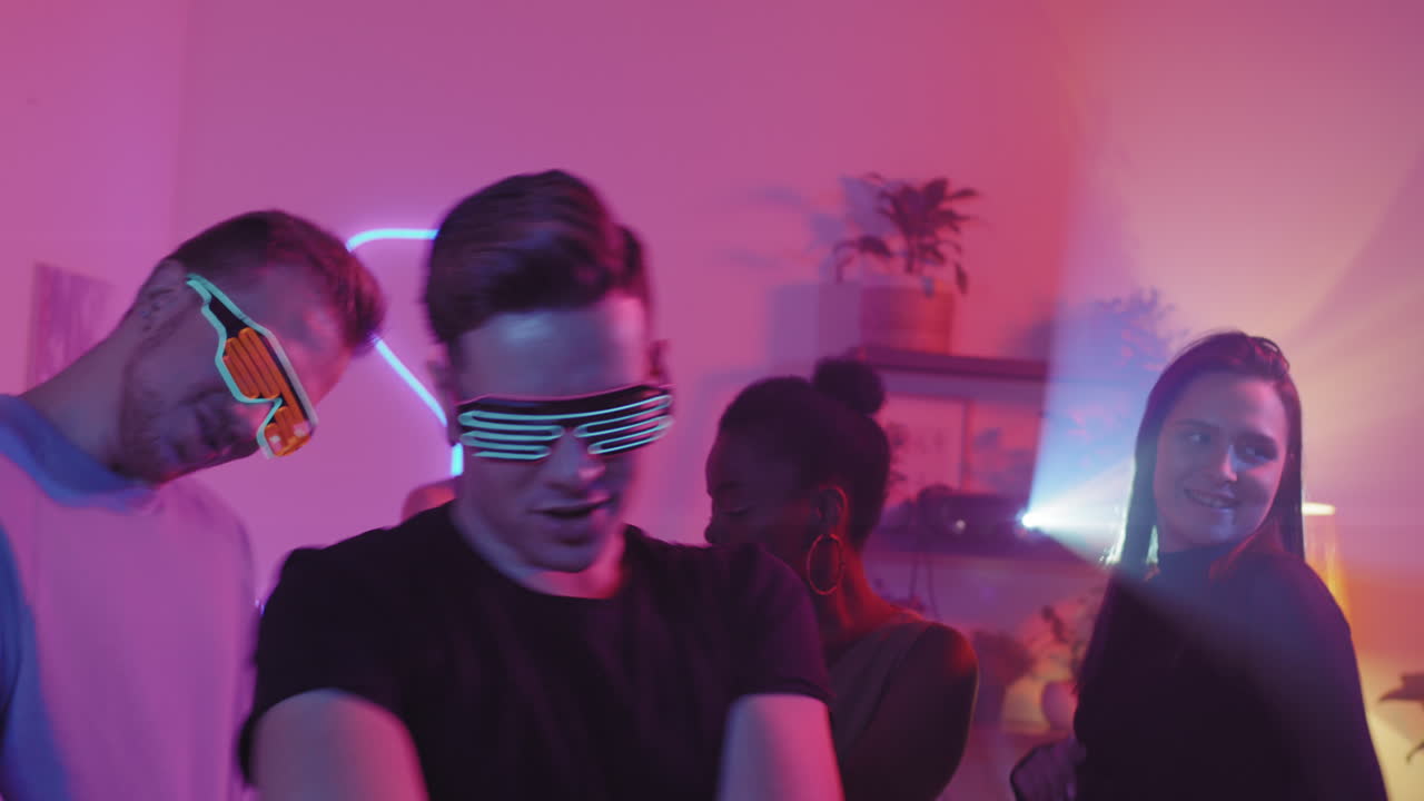 Young Man in Neon Sunglasses Dancing at House Party