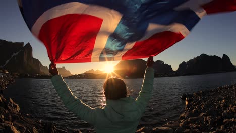 Frau-Schwenkt-Bei-Sonnenuntergang-Die-Flagge-Norwegens