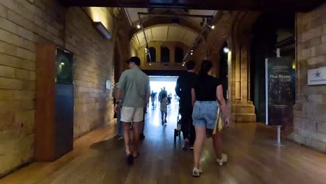 people exploring museum hallway in london