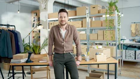 cucasian designer man looking at camera in a good mood in a fashion clothing store