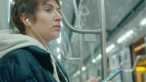 young woman using phone in subway train