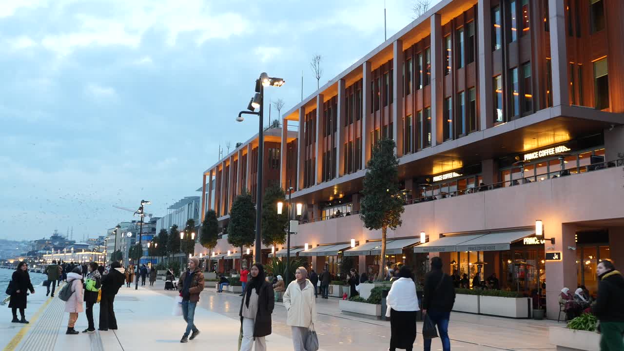 밤 에 이스탄불 의 해안 거리 를 따라 고 있는 사람 들