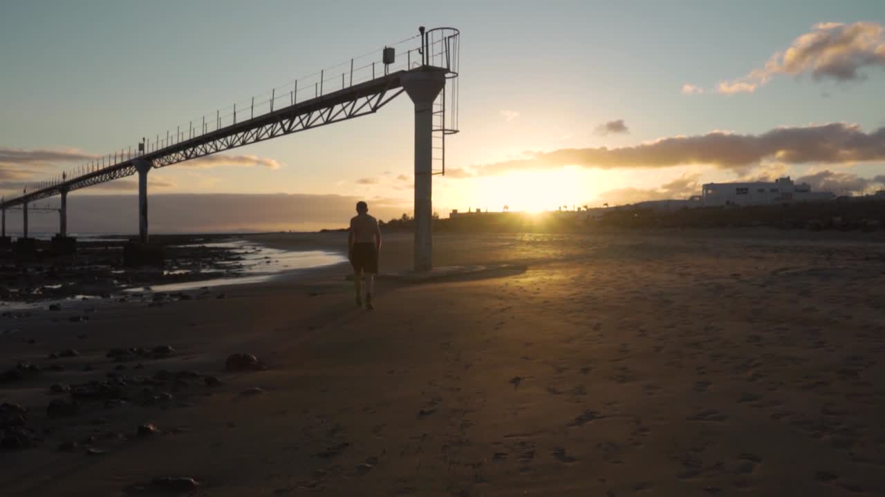 해가 지면 해변을 고 있는 남자