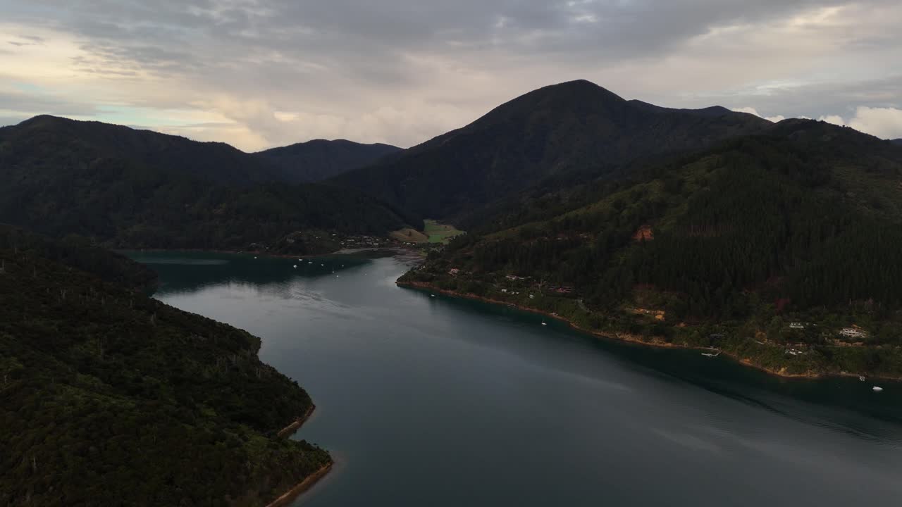 Dusk and cloudy summer scene in picton area with port and boats in distance. Aerial wide shot. New Zealand South Island coastline