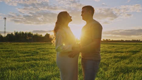 pregnant couple at sunset