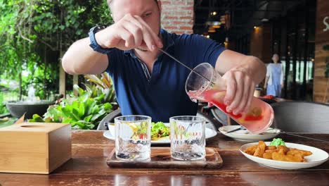 man pouring drinks at a restaurant