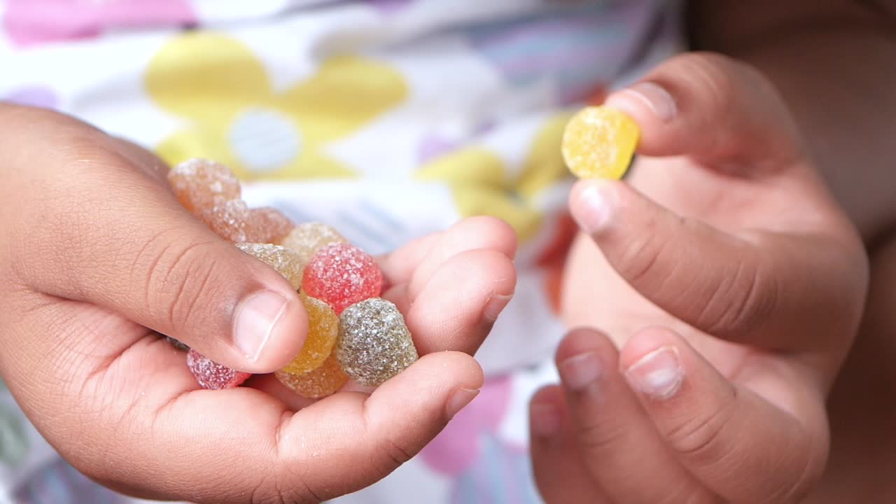 Child holding colorful gummy candies