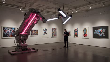 exploring the intersection of art and technology: a robotic arm engaging with vibrant artwork in a modern gallery setting