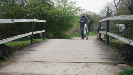 woman cycling on a wooden bridge in the countryside