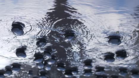 man in reflection spills coal out over wet ground