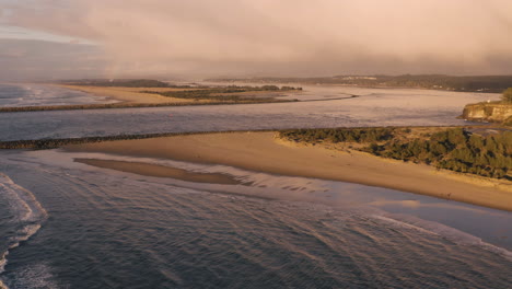 drone flying high over bastendorff beach near coos bay oregon towards the harbor and bay entrance