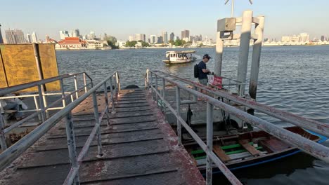 person disembarks boat, walks along the pier