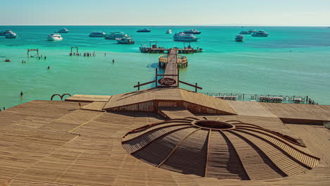 Disparo-En-ángulo-Alto-Sobre-Los-Turistas-Caminando-En-Un-Muelle-De-Madera-Rodeado-De-Hermosas-Aguas-Turquesas-En-Un-Día-Soleado-En-Timelapse