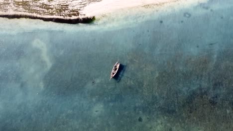 Drone-view-on-a-traditional-boat-on-Nungwi-beach,-Zanzibar-Island,-Tanzania,-Africa,-Indian-Ocean