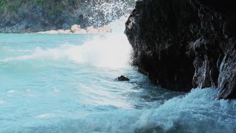 Cámara-Lenta-Estática-De-Poderosas-Olas-Azules-Del-Océano-Pacífico-Que-Se-Estrellan-Contra-La-Pared-Rocosa-De-La-Costa-Hawaiana-En-Verano