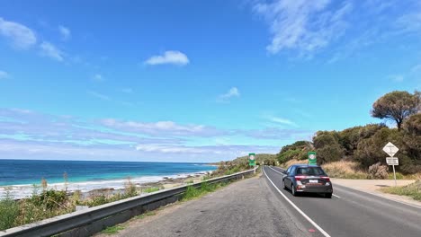 a picturesque drive showcasing coastal views, winding roads, and lush greenery under clear blue skies